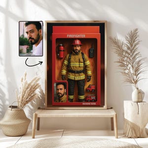 May include: Framed artwork showing a firefighter action figure in a red box. The figure is dressed in a yellow uniform, black trousers, and a red helmet. Accessories include a fire extinguisher, radio, and miniature fire engines. The box is labelled "FIREFIGHTER" and includes the name "RICHARD KERN".
