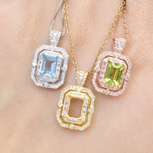 May include: Three gemstone pendant necklaces. One features a light blue stone in a silver setting, another a yellow stone in a gold setting, and the third a green stone in a rose gold setting. Each pendant has a rectangular shape and is surrounded by smaller accent stones.