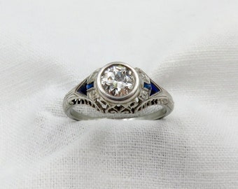 Art Deco Diamond and Platinum Engagement Ring centered with a 0.75 ct Early Modern Round Brilliant Cut Diamond. F Color
