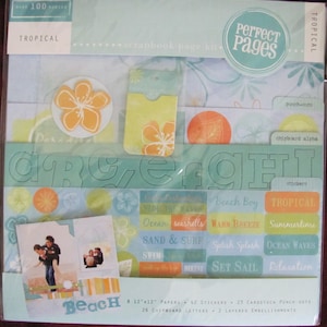 May include: A tropical scrapbook page kit with over 100 pieces. Includes papers, stickers, chipboard letters, and layered embellishments. Features a beach theme with orange and yellow floral accents and the words "Beach", "Tropical", and "Perfect Pages".