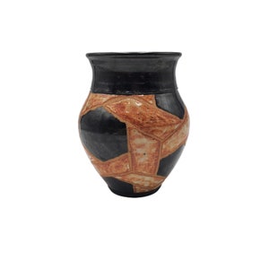 May include: A black and orange ceramic vase with a geometric pattern. The vase has a rounded body and a narrow opening.