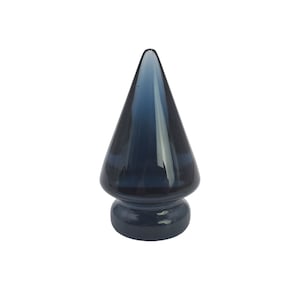 May include: A dark blue glass bottle stopper shaped like a Christmas tree.
