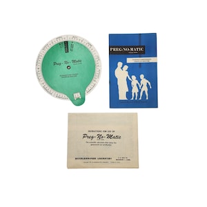 May include: An assortment of vintage items, including a green and white Preg-No-Matic fertility calculator, a blue booklet titled "Preg-No-Matic," and an instruction sheet. The calculator features a rotating dial with month markings.