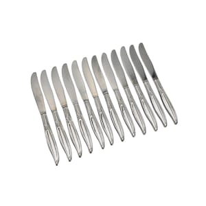 Puede incluir: Un juego de doce cuchillos de mantequilla de plata con mangos adornados.