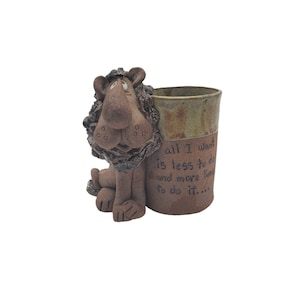 May include: A ceramic mug with a lion figurine attached to the side. The mug has a brown and green glaze and the text "all I want is less to do and more time to do it..." is written on the side.
