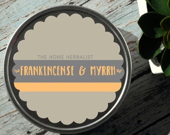May include: A round metal tin with a gray and orange label that reads "The Home Herbalist ~Frankincense & Myrrh~"