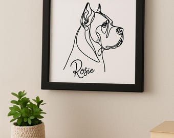 Op de afbeelding: Een ingelijste zwart-wit lijntekening van een hondenprofiel. De naam van de hond, "Rosie", is in cursief onder de afbeelding geschreven. Het kunstwerk wordt weergegeven op een witte achtergrond in een zwart frame, geschikt voor woondecoratie.
