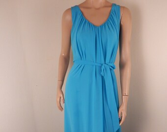 May include: A sleeveless, turquoise maxi dress with a V-neckline and a matching waist tie. The dress features a flowing, floor-length skirt and is displayed on a mannequin.