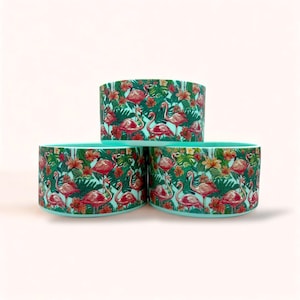 May include: Three turquoise ceramic bowls with a tropical flamingo and floral print. The bowls are stacked on top of each other.