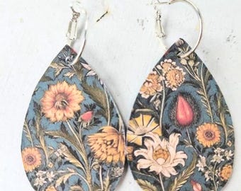 May include: A pair of teardrop-shaped earrings with a floral pattern. The earrings are made of leather and have silver-toned hoops.