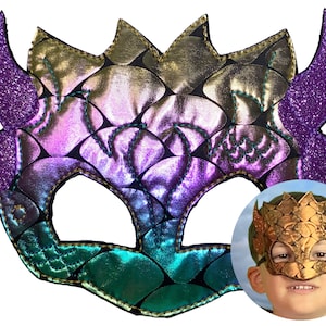 May include: A handcrafted dragon mask with a shimmering, iridescent scale pattern in shades of purple, green, and gold. The mask features glittery purple horns and is designed for costume or play. The mask is shown in a close-up and a child wearing the mask.