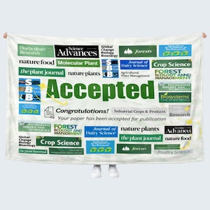 May include: A white blanket with the word "Accepted" in large green letters. The blanket is covered with various journal titles and the text "Congratulations! Your paper has been accepted for publication."