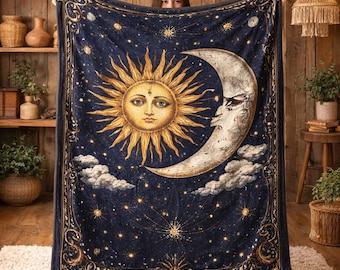 May include: A navy blue blanket featuring a celestial design with a sun, moon, stars, and clouds. The sun and moon have detailed faces, and the blanket has a decorative border. The blanket is held up by a person.