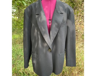 May include: A black blazer with a single gold button closure. The blazer has a notched lapel and a relaxed fit.