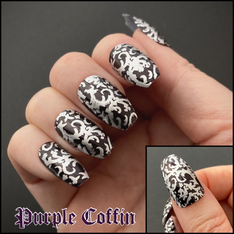 A female hand is wearing purple coffin-shaped  alse nails with silver detailing. the background is black, and text reads purple coffin. Small inset photo on the lower right shows a white female thumb with the same nail.