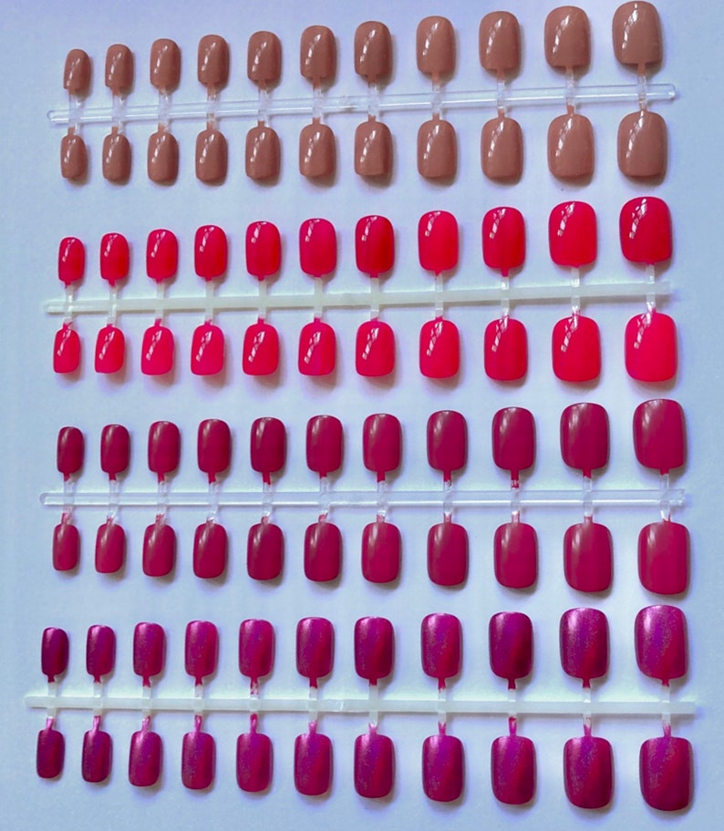 4 sets of short oval press on nails are shown in dusty rose, medium pink, fuchsia and metallic rose on a white background.