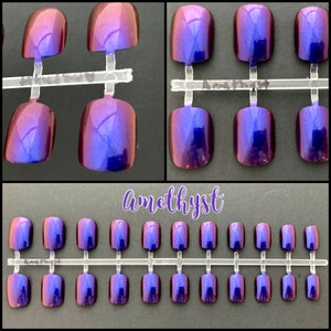 Short purple to fuchsia duochrome false nails shown on a black background. Top two photos show close up view. Text reads Amethyst. bottom picture shows full set of 24 press on nails.