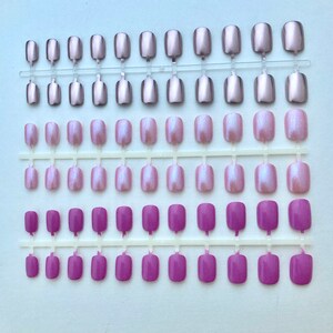 3 sets of short false nails in Metallic pink, iridescent light pink and lilac pink are shown on a white background.