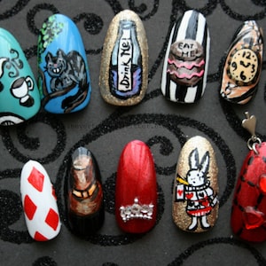 Ten hand-painted press on nails depicting images from Alice In Wonderland - Tea, Cheshire Cat, "Drink Me" bottle, "Eat Me" cake, clock, top hat, rabbit and playing card