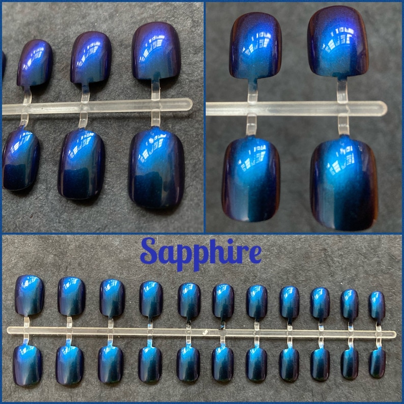 Short blue purple duochrome false nails shown on a black background. Top two photos show close up view. Text reads sapphire. bottom picture shows full set of 24 press on nails.