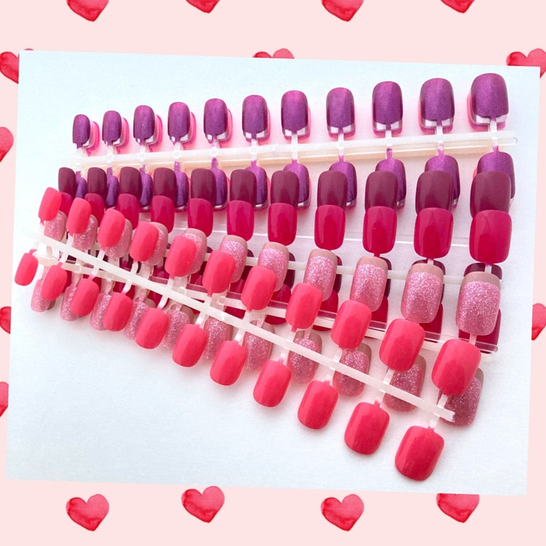 Bundle of 10 petite active sets of press on nails in neon pink, rose glitter, magenta and other pink shades rest on a white background. pink frame with red hearts surrounds the image.