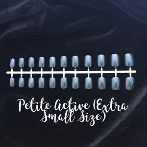 Black holographic short press on nails on a black velvet background. White cursive text reads petite active extra small size