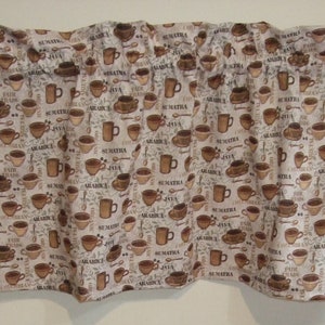May include: A brown and white fabric valance with a coffee theme. The valance features a repeating pattern of coffee cups, coffee beans, and the words "Sumatra", "Java", and "Arabica".