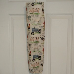 K&ouml;nnte beinhalten: Ein wei&szlig;er Plastik-Taschenspender mit einem Bauernhof-Motiv. Der Spender zeigt ein sich wiederholendes Muster aus Schweinen, K&uuml;hen, H&uuml;hnern und einem Traktor mit dem Text "On the Farm".