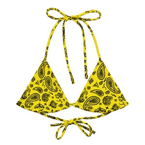 May include: A yellow halter bikini top with a black paisley pattern. The top ties at the neck and back with matching yellow fabric ties. The triangle cups are connected at the center.