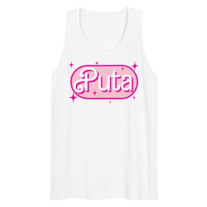 May include: White tank top with a pink oval graphic that reads "Puta" in a stylized font. The graphic is outlined in white and surrounded by pink starbursts. The tank top is sleeveless.