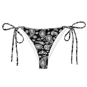 May include: Black and white paisley print bikini bottoms with tie sides. The bottoms feature a classic bandana pattern in black and white, with white lining. The tie sides allow for an adjustable fit.