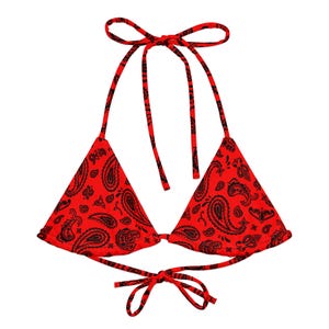 Puede incluir: Top de bikini con estampado de cachemira rojo y negro con lazos halter. La parte superior triangular presenta un patrón de bandana clásico y lazos en el cuello y la espalda para un ajuste regulable. Una pieza de traje de baño elegante.