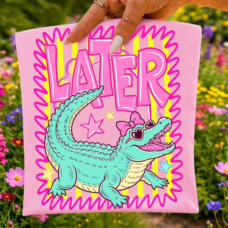 A mockup displaying the Later Gator PNG digital design applied to a pink t-shirt, demonstrating its potential for custom apparel.