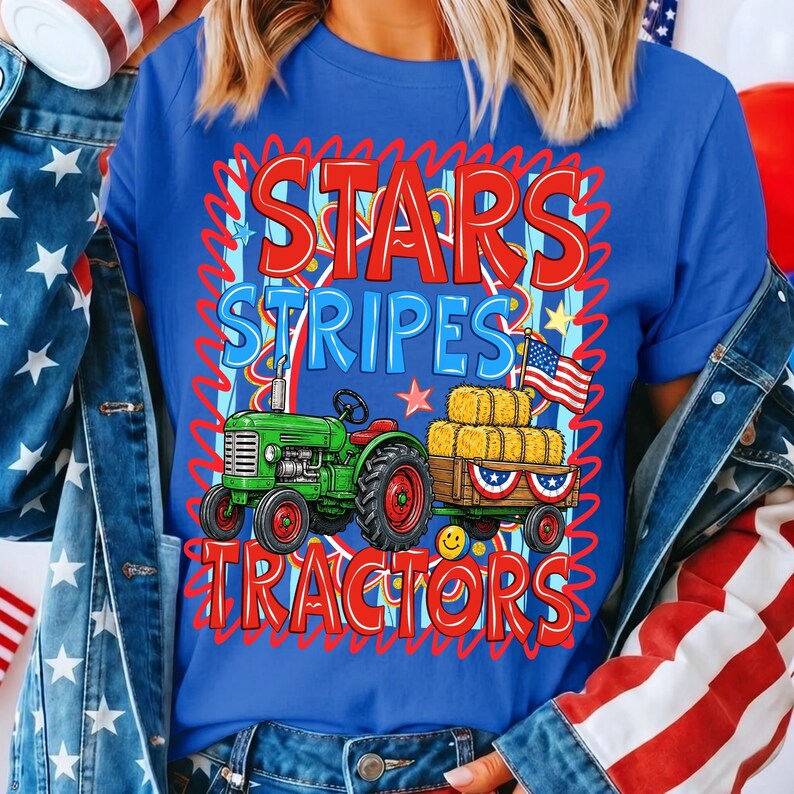 Pode incluir: Camiseta azul com um gr&aacute;fico com um trator verde puxando uma carro&ccedil;a de fardos de feno, uma bandeira americana e as palavras "STARS STRIPES TRACTORS" em vermelho e azul. O design tem um tema patri&oacute;tico.