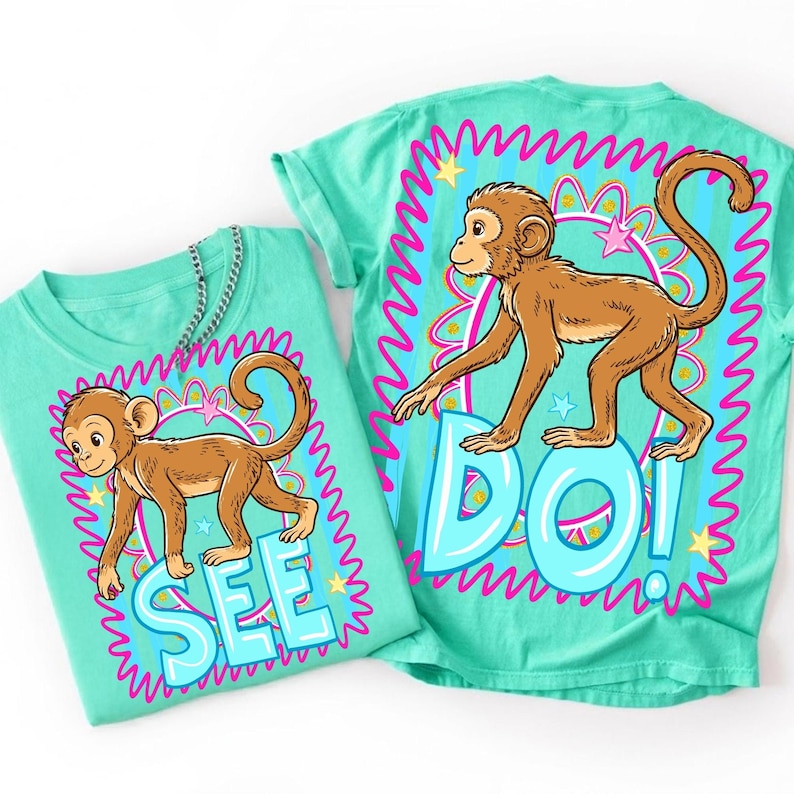 May include: Two turquoise t-shirts with a cartoon monkey design. One shirt says "SEE" and the other says "DO!" in large, light blue letters. The monkey is brown with a long tail, and the design is framed by a pink and blue border.