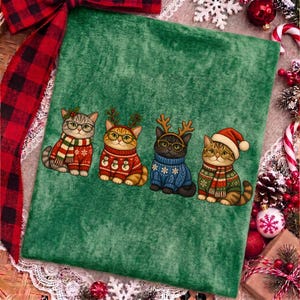 K&ouml;nnte beinhalten: Ein gr&uuml;nes Stoffquadrat mit einer aufgedruckten Illustration von vier Katzen, die Brillen und Weihnachtspullover tragen. Die Katzen sind mit festlichen Accessoires wie einem Schal, Rentiergeweih und einer Weihnachtsm&uuml;tze in einer Reihe.