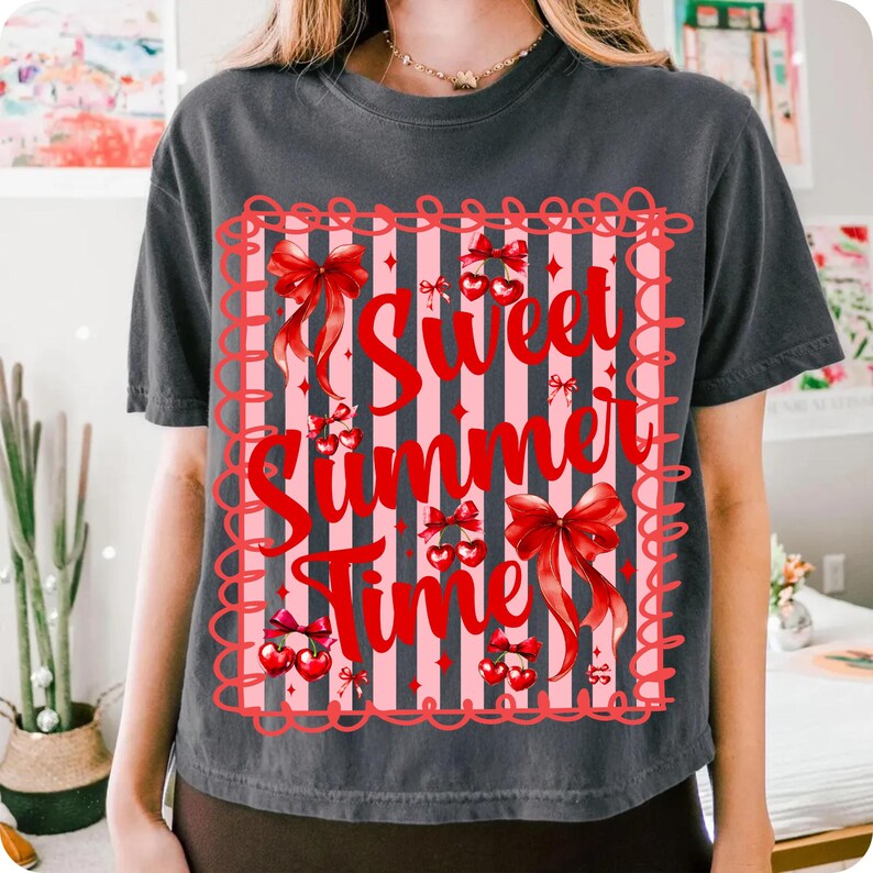 Pu&ograve; includere: T-shirt grigio scuro con grafica rossa e rosa con la scritta "Sweet Summer Time". La grafica presenta fiocchi rossi, ciliegie e uno sfondo a righe. La maglietta &egrave; a maniche corte.