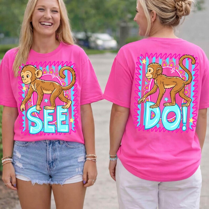 May include: Pink t-shirts with a cartoon monkey design. The front of the shirt says "SEE" in blue letters, and the back says "DO!" in blue letters. The monkey is brown and is inside a blue and pink frame.