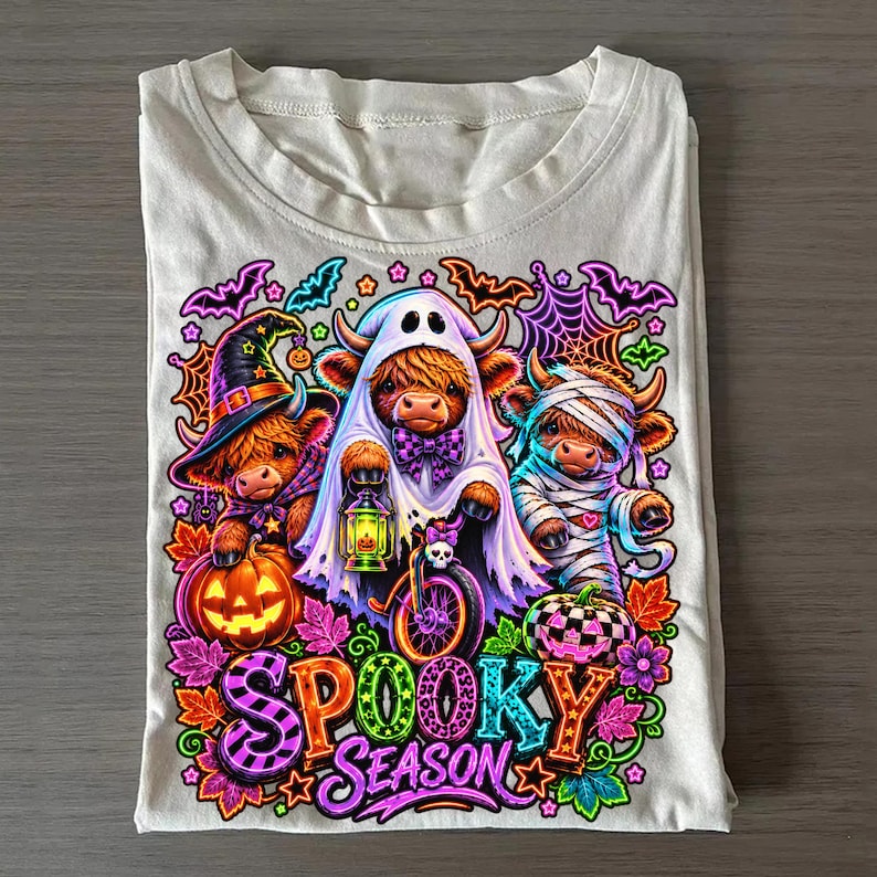 Mockup of a t-shirt featuring the Neon Highland Cow Halloween sublimation design.