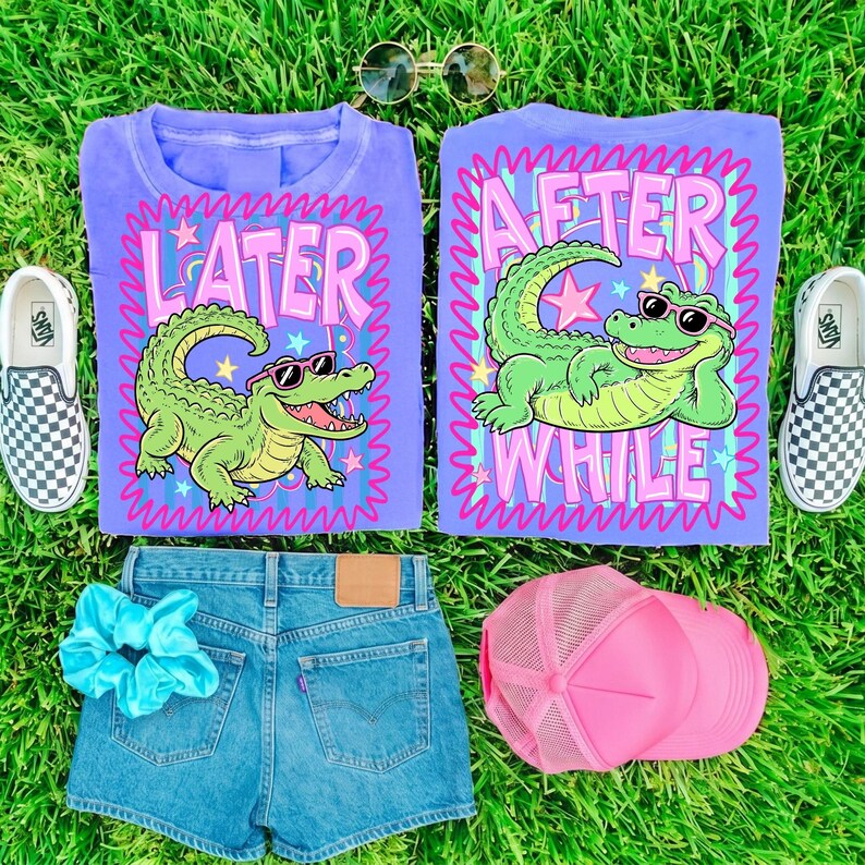May include: A flat lay featuring two purple t-shirts with alligator graphics and the phrases "LATER" and "AFTER WHILE". The image also includes denim shorts, a pink trucker hat, a blue scrunchie, sunglasses, and checkered slip-on shoes.