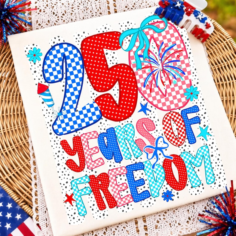 K&ouml;nnte beinhalten: Ein wei&szlig;es T-Shirt mit einem Grafikdesign und dem Text 250 YEARS OF FREEDOM. Die Zahlen und Buchstaben sind mit rot-wei&szlig;-blauen Karomustern und Punkten gef&uuml;llt, verziert mit blauen Schleifen, Feuerwerksmotiven und kleinen Sternsymbolen.