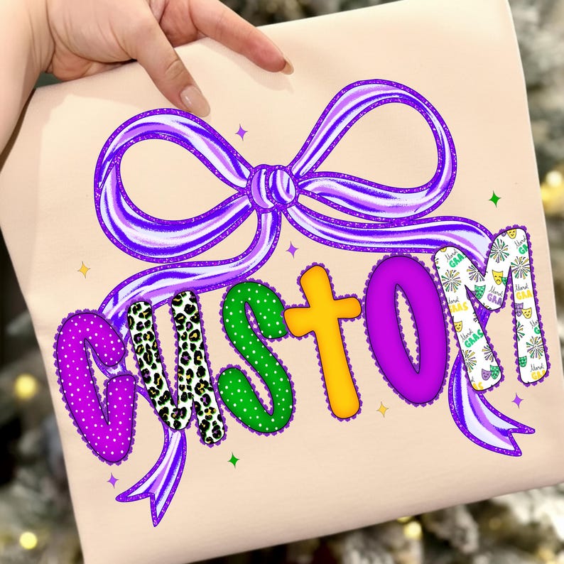 May include: A light beige item with a large purple bow and the word "CUSTOM" in colorful letters. The letters have various patterns, including polka dots, leopard print, and Mardi Gras-themed designs. The bow and letters are outlined in a darker purple.