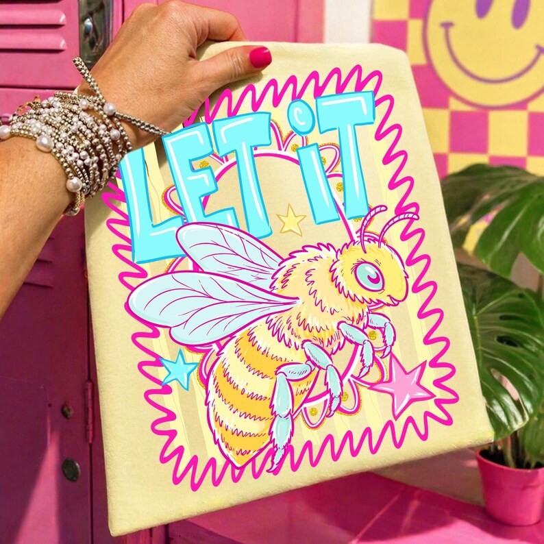 May include: A light yellow canvas with a cartoon bee illustration and the words "LET IT" in blue letters. The bee is yellow and orange with blue wings, surrounded by pink stars and a pink wavy border.