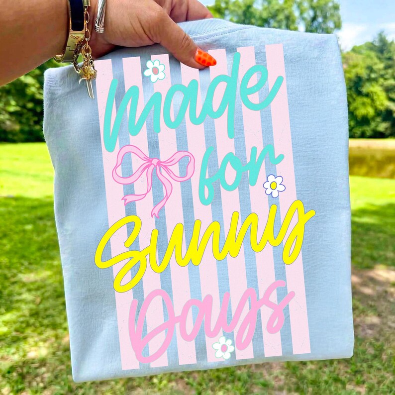 Close-up of the 'Made for Sunny Days' striped beachy coquette design with a pink bow and retro typography.