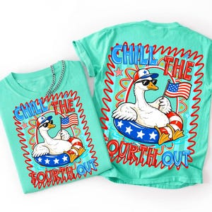 Peut inclure: Deux t-shirts turquoise avec un motif graphique. Le motif repr&eacute;sente une oie blanche portant des lunettes de soleil et un chapeau patriotique, flottant dans une bou&eacute;e bleue et rouge, tenant un drapeau am&eacute;ricain. Le texte "CHILL THE FOURTH OUT" est affich&eacute;.