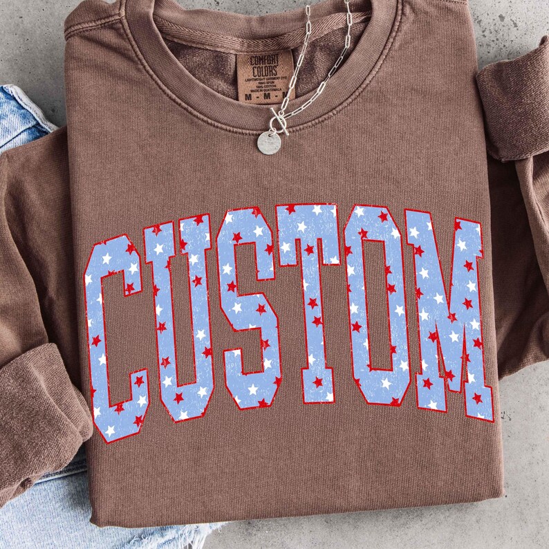 Mockup of a custom t-shirt featuring a personalized patriotic varsity letter.
