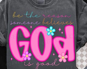 May include: Dark gray sweatshirt with the words "be the reason someone believes GOD is good" in colorful script and bubble letters. The word "GOD" is in large pink letters with flower accents.