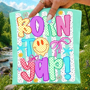 May include: A mint green tote bag featuring the phrase "BORN TO YAP!" in vibrant, cartoonish letters. The design incorporates a smiley face, bows, flowers, and stars. The background has white stripes and polka dots.