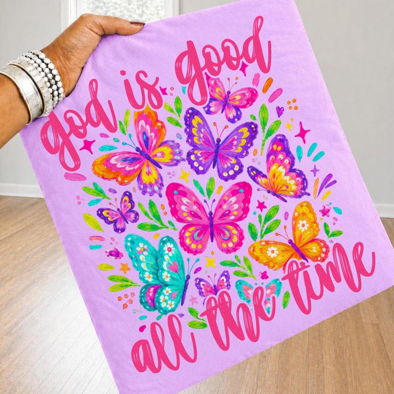 Peut inclure: Une couverture lavande orn&eacute;e d'un motif de papillons color&eacute;s et de l'inscription rose vif &laquo; God is good all the time &raquo;. Les papillons sont de diff&eacute;rentes couleurs, dont le rose, l'orange et le turquoise.