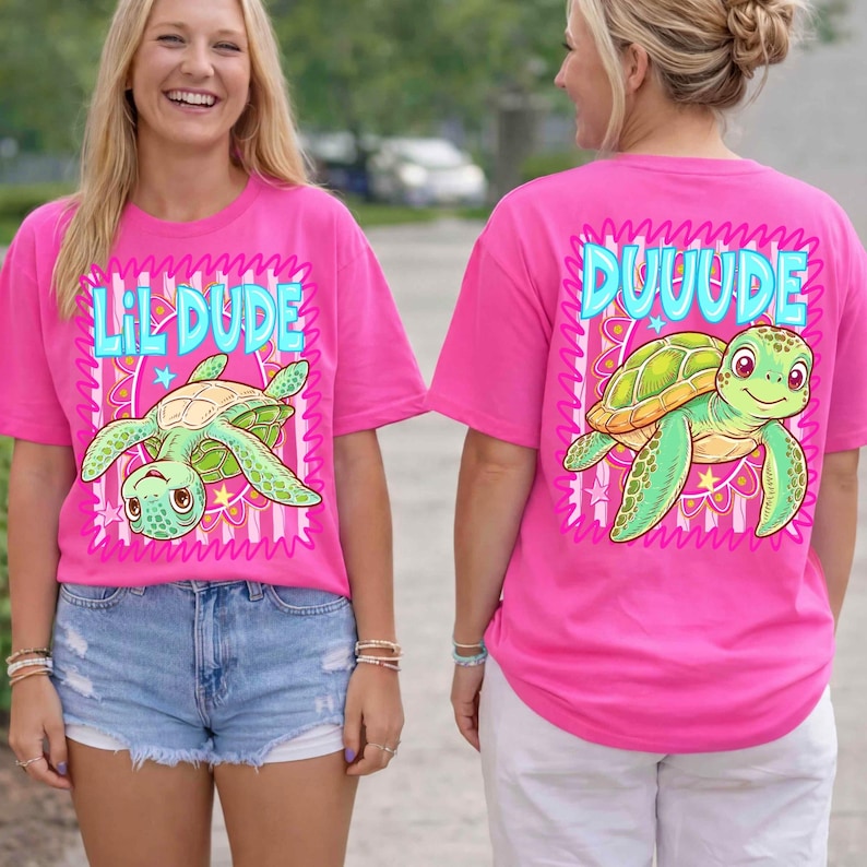 May include: Bright pink t-shirts featuring a cartoon turtle design. The front of the shirt says "Lil Dude" and the back says "Duuude". The turtle is green and yellow with a smiling face.